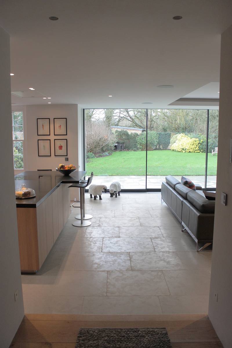 Dalles en pierre naturelle grège Avallon, qui apportent des nuances subtiles et une ambiance chaleureuse à cet espace intérieur lumineux.