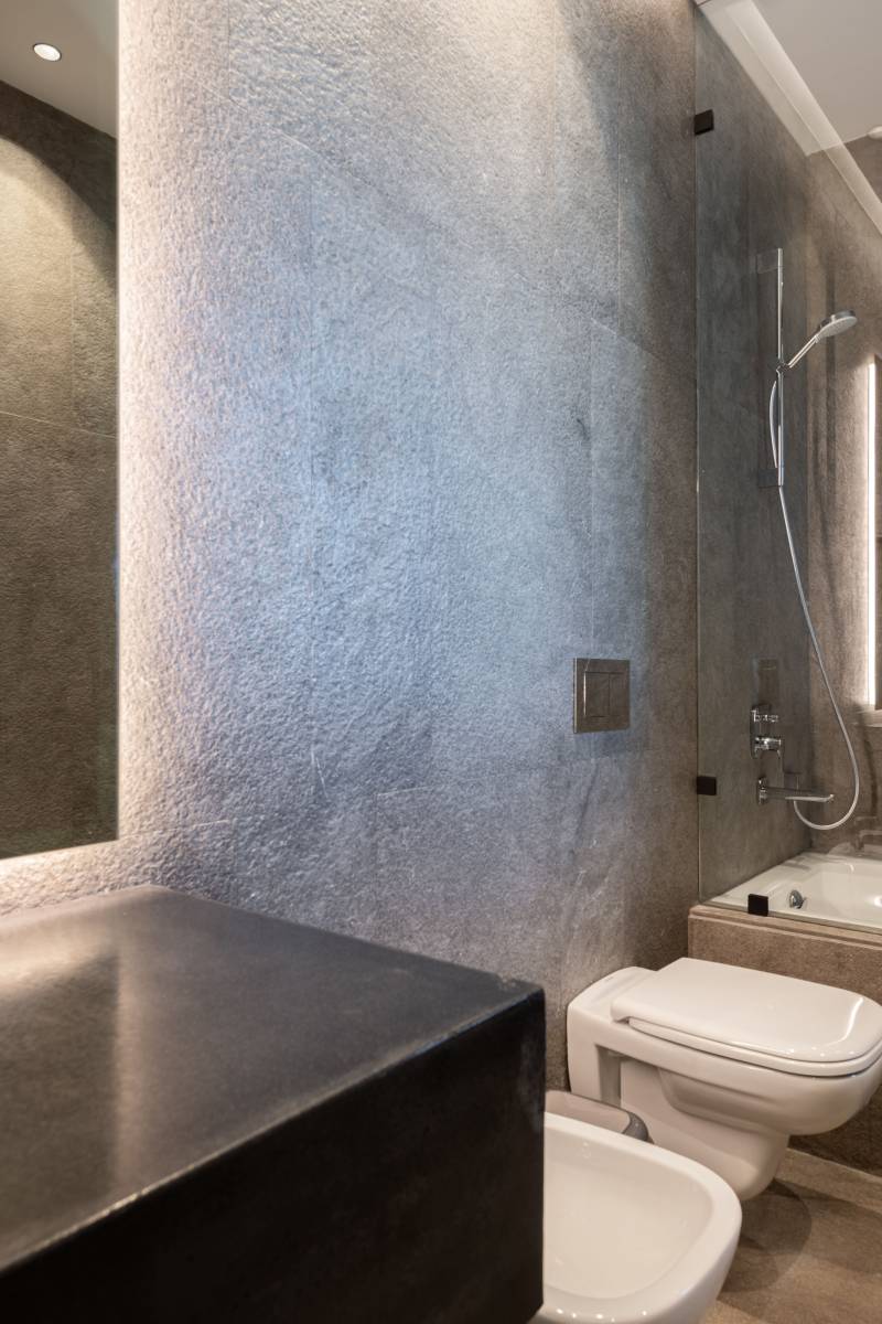 Revêtement sol et mur en pierre naturelle finition antidérapante flammé-brossé pour salle de bain moderne