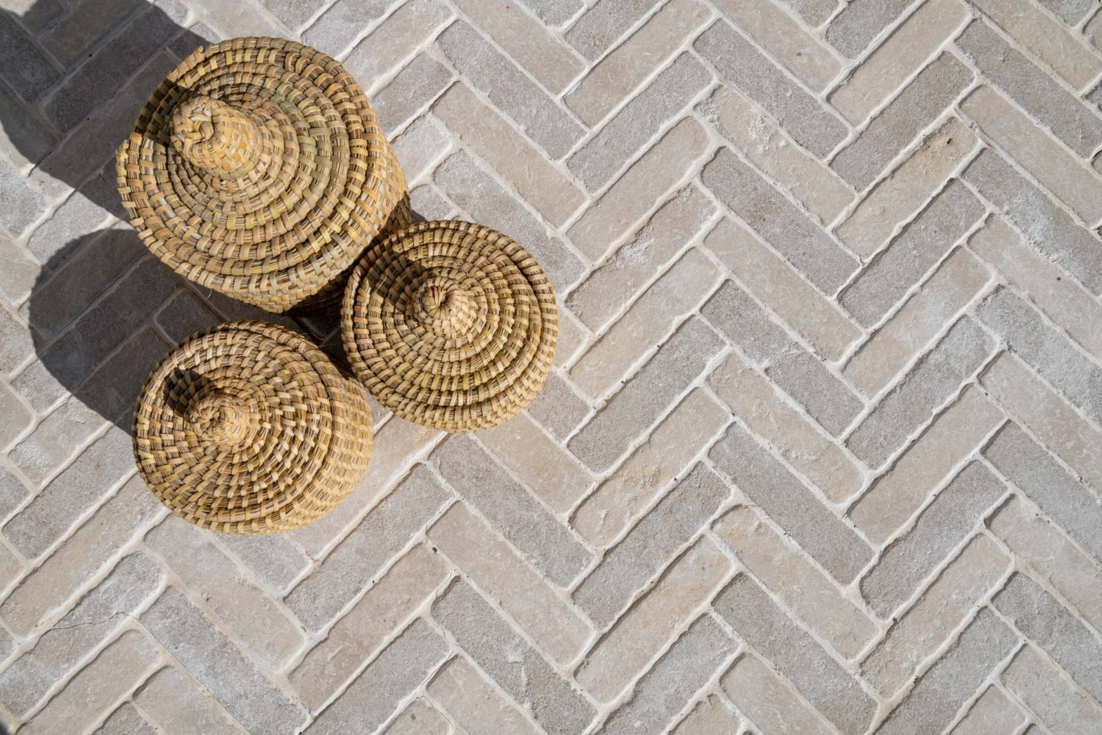 Pavés en pierre naturelle beige du Maroc en pose chevron – mélange de nuances beige et grège – alternative à la pierre de Bourgogne pour terrasse et allée extérieure.