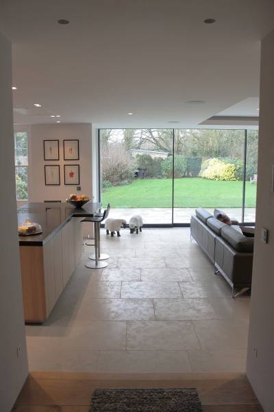 Dalles en pierre naturelle grège Avallon, qui apportent des nuances subtiles et une ambiance chaleureuse à cet espace intérieur lumineux.