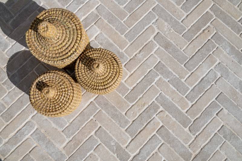 Pavés en pierre naturelle beige du Maroc en pose chevron – mélange de nuances beige et grège – alternative à la pierre de Bourgogne pour terrasse et allée extérieure.